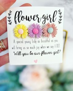 a hand holding a card with three flowers on it and the words, flower girl