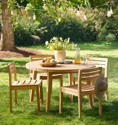 a wooden table and chairs in the grass