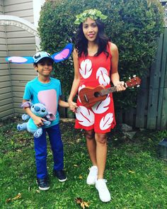 a woman standing next to a young boy wearing bunny ears and holding a ukulele