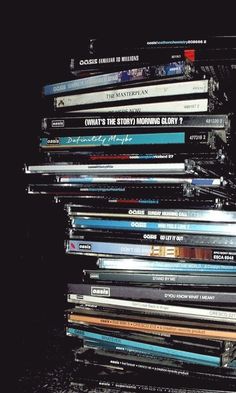 a stack of cds sitting on top of each other in front of a black background