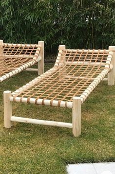 two wooden lawn chairs sitting on top of grass