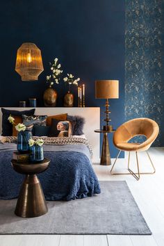 a bedroom with blue walls and gold accents