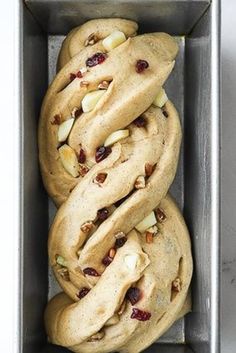 two cookies in a metal pan with nuts and cranberries