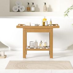 a white bath tub sitting next to a wooden table