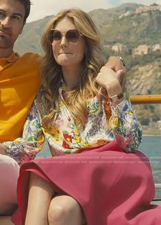 a man and woman sitting next to each other on a boat in front of the ocean