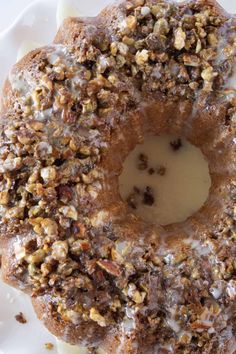 a close up of a doughnut on a plate with icing and nuts around it