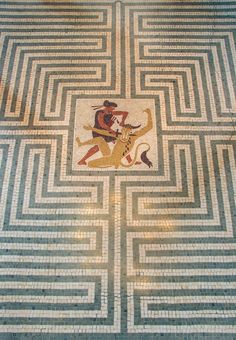 an artistic mosaic in the middle of a floor with a man riding a horse on it