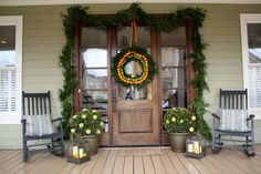 front porch decorated for christmas with wreath and potted plants