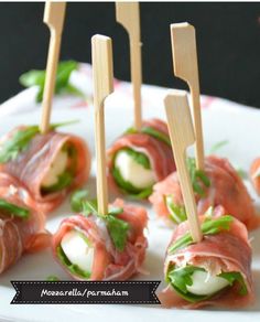 small appetizers with toothpicks are arranged on a plate