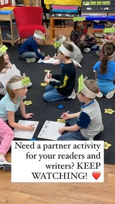 children are sitting on the floor and reading books with paper crowns in front of them