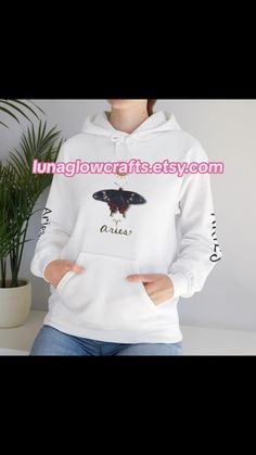 a woman wearing a white hoodie with a butterfly on it