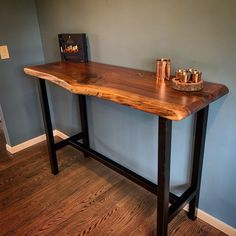 a wooden table with metal legs in a blue walled room next to a wood floor