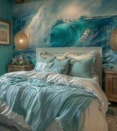 a bedroom decorated in blue and white with a large wave painted on the wall behind the bed