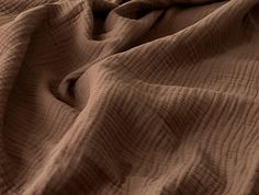 the texture of an unmade bed is brown