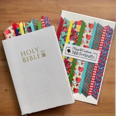 two bibles are sitting on a table next to each other with colorful ribbons around them