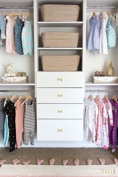 an organized closet with baby clothes and baskets on the shelves, along with other items