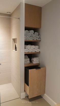 the bathroom is clean and ready to be used as a storage area for folded towels