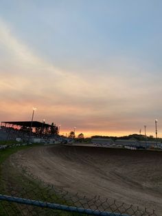 a dirt bike track with the sun setting in the background