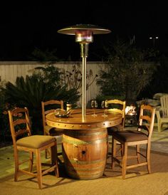 an outdoor table with chairs around it in the evening time, next to a fire pit