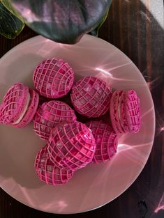 some pink waffles on a white plate next to a potted green plant