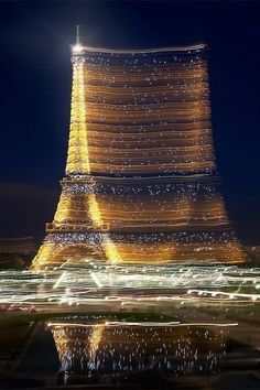 the eiffel tower is lit up at night with lights on it's sides