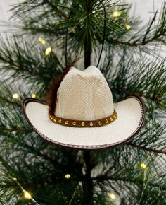 a cowboy hat ornament hanging from a christmas tree