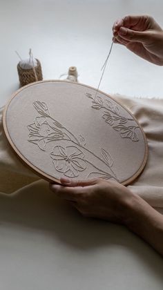 a woman is working on an embroidery project