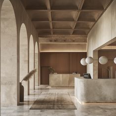 an empty lobby with columns and lights on either side of the counter, in front of a row of mirrors