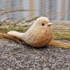 a small wooden bird sitting on the ground