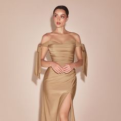 Discover The Epitome Of Modern Elegance And Irresistible Charm With Our Long Stretch Jersey Sheath Dress, A Stunning Ensemble That Radiates Contemporary Sophistication. Designed For The Woman Who Moves Gracefully Between The Worlds Of Timeless Style And Current Trends, This Dress Is A Celebration Of Confidence And Allure. Fabric: Stretch Jersey Length: Long Color: Nude Gold Neckline: Sweetheart Silhouette: Sheath Sleeve: Off Shoulder Tie Back: Zipper Skirt: Leg Slit Occasion: Romantic Date/Eveni Beige Off The Shoulder Dress, Gold Gowns Elegant, Gold Gowns Elegant Classy, Gold Off The Shoulder Dress, Beige Evening Dress, Champagne Cocktail Dress, Cream Dresses, Off Shoulder Evening Dress, Long Cocktail Dress