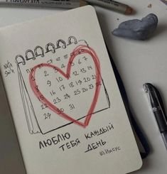 a notepad with a drawing of a heart on it and two markers next to it