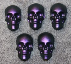 four purple skulls sitting on top of a carpet