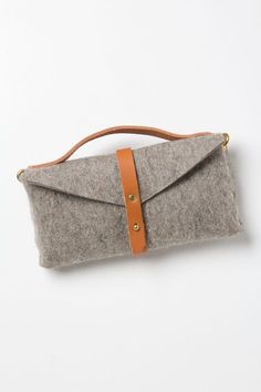 a gray and brown purse sitting on top of a white table