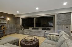 a living room filled with furniture and a flat screen tv mounted to the side of a wall