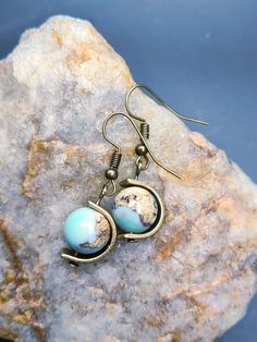 Perfect gift for geography enthusiasts and fidgeters alike! These earrings are made from naturally occurring agate that mimics the look of a tiny planet Earth. Each unique globe rotates on an antiqued brass axis. A thick, durable brass frame protects and spins around each globe. PLEASE NOTE: These are made to order. Your pair will not be exactly as pictured. I will send you a picture of your unique pair before confirming your order. Globe Earrings, Tiny Planet, Earth Globe, Brass Frame, Planet Earth, Antique Brass, Jewelry Earrings Dangle, Planets, Etsy Earrings