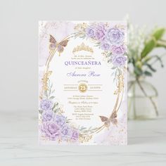 a purple and gold quinceauera wedding card on a table next to flowers