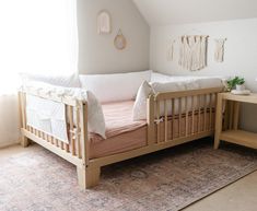 a baby's bed in the corner of a room with a rug on the floor