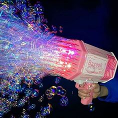 a person holding a blow dryer in their hand with bubbles coming out of it