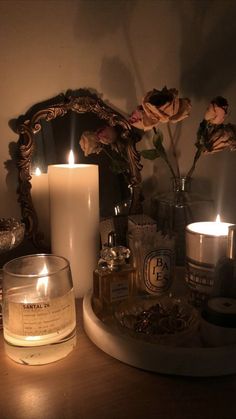 some candles are sitting on a table next to a mirror