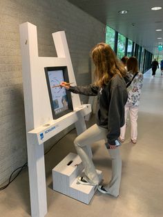 two girls standing in front of an interactive screen