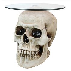 a glass topped table with a skull head on it's face and the top half covered in black eyes