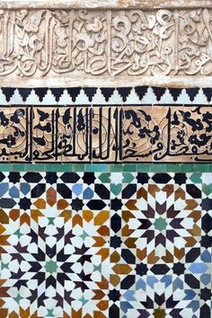 an intricate tile work on the side of a building with arabic writing and geometric designs