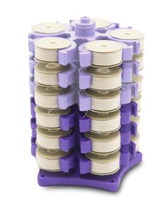 several spools of thread are stacked on top of each other in a purple holder