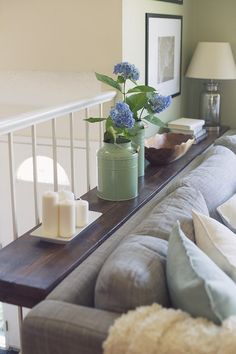 a living room filled with furniture and flowers on top of a wooden table next to a window