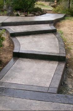 a concrete walkway with steps leading up to the top