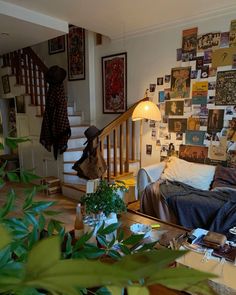 a living room filled with furniture and lots of pictures on the wall next to stairs