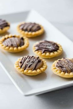 small cookies with chocolate frosting on a white plate