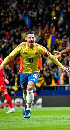 the soccer player is celebrating his goal in front of an excited crowd as he runs towards the ball