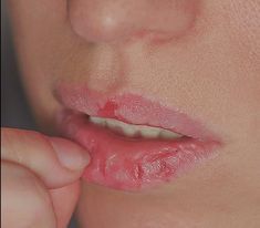 a close up of a woman's lips with her hand on the lip and nose