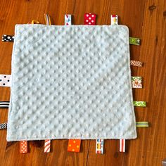 a baby's blanket is laying on the floor next to some tape and scissors